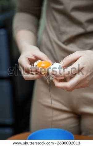 person's hands skillfully separating egg white from yolk using eggshell halves. The process showcases culinary technique and precision in cooking