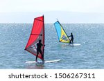 persons learning to windsurf off the island Alameda in the San Francisco Bay. Windsurfing a surface water sport that combines elements of surfing and sailing.