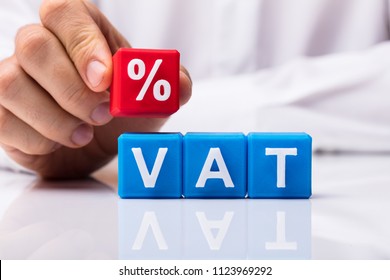 Person's Placing Red Percentage Block Over Vat On White Background