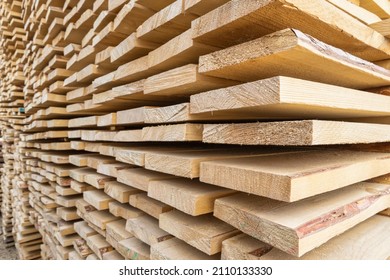 Perspective angle of wooden planks in close-up at a lumber warehouse. Background of boards. - Shutterstock ID 2110133330