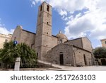 Perspective of the Church of San Paolo, a historic 18th-century Romanesque church located in the center of Olbia, Sardinia, Italy, with a colorful dome and a large bell tower. No people