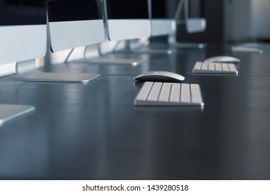 Perspective Closeup View Of Keyboards Workstation Computers And Mouse On Desk In A Digital College Training Center