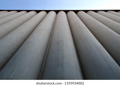 Perspective looking up at large industrial concrete storage silos at a flour mill.