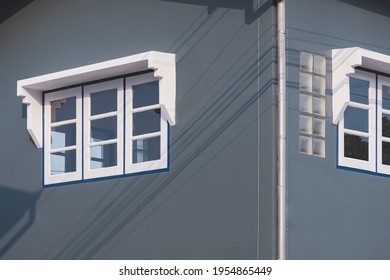 Perspective And Low Angle View Of White Glass Windows On Gray Cement Wall Of House 