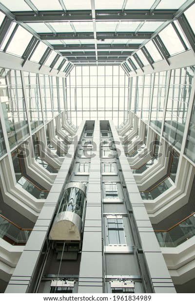 Perspective of office lobby: round-shaped\
roof and glassy walls in modern hall with\
elevator