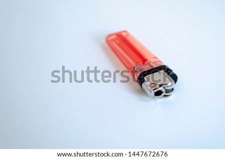 Perspective open shoot of transparent horizontal orange lighter on white surface
