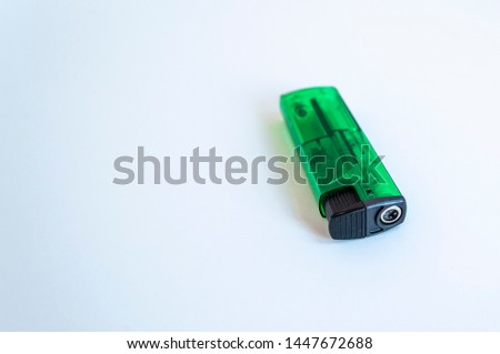 Perspective open shoot of transparent horizontal green lighter on white surface