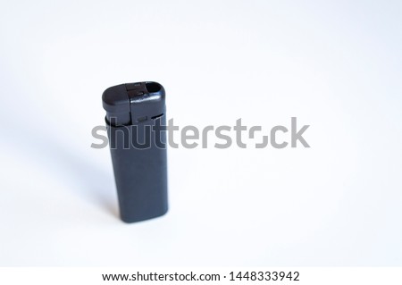 Perspective open shoot of vertical black lighter on white surface