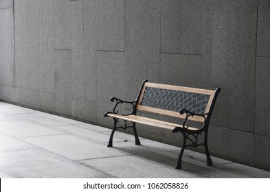 Perspective Outdoor Bench In Open Empty Space Area With Concrete Floor Tile And Wall. Bench In Dramatic Light And Color