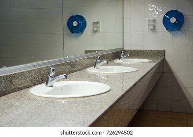 Perspective Of Public Restroom Show The Mirror, Sinks, Sanitary, Tissue Paper Box And Hand Soap Bottle At The School.