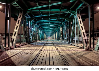 Perspective rail bridge by night. Vanishing point Gdanski tram bridge in Warsaw, Poland. Colorful game of shadow and light
