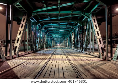 Perspective rail bridge by night. Vanishing point Gdanski tram bridge in Warsaw, Poland. Colorful game of shadow and light