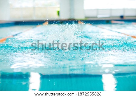 Perspective of a single olympic pool with a slpash. Line divisions
