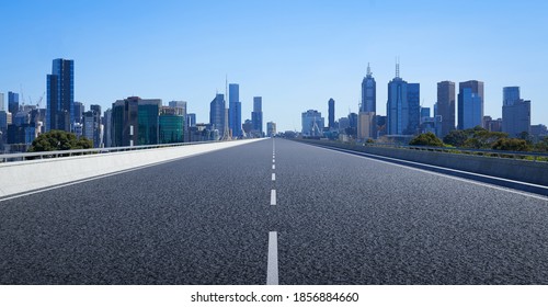 Perspective straight empty highway road with modern cityscape. Morning scene view .