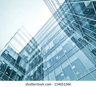 Perspective And Underside Angle View To Textured Background Of Modern Glass Building Skyscrapers At Night