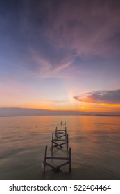 Perspective view of a  abandoned wooden pier on sunset with perfectly specular reflection.Nature composition, vibrance color and grain effect.