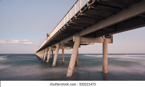 Perspective View Below The Gold Coast Iconic Jetty With a Misty Ocean at Dusk, The Spit, Philip Park, Main Beach, Queensland, Australia