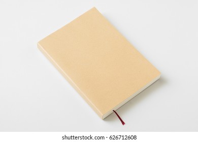 Perspective View Of Closed Book Mock Up Brown Cover On White Desk Background