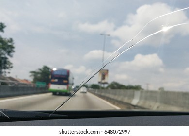 Perspective view of cracked car windscreen or windshield from inside vehicle while driving