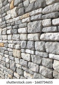 Perspective View Of Decorative Natural Cobble Stone Wall With Different Shades Of Grey And Sizes, Shadow Gap. Natural Texture And Form. External Wall Covering. 