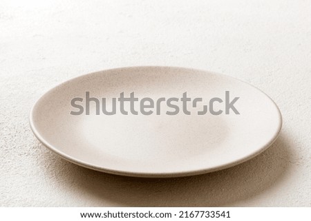 Perspective view of empty light plate on wooden background. Empty space for your design.