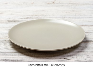 Perspective view. Empty white plate on wooden background. - Powered by Shutterstock