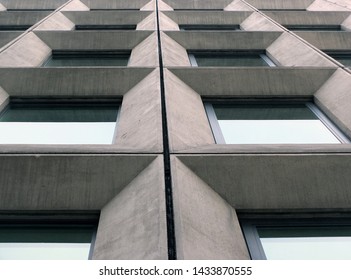 perspective view of geometric angular concrete windows on the facade of a modernist 1960s brutalist style building