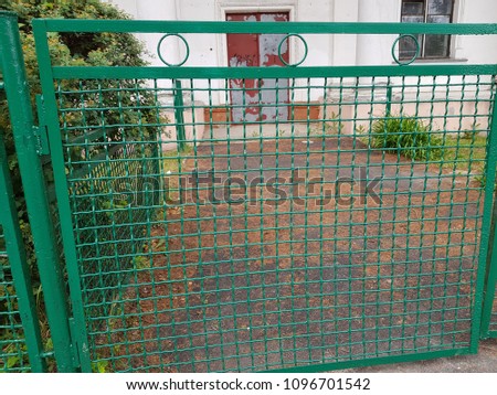 Perspective view of a green chain link fence as seamless background with strong geometric patterns, tones and texture