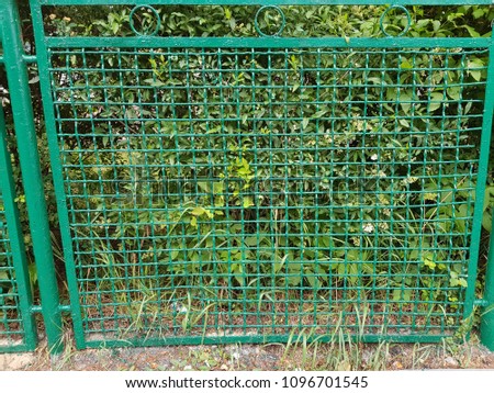 Perspective view of a green chain link fence as seamless background with strong geometric patterns, tones and texture