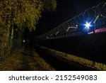Perspective view of the illuminated unnamed alley between the Stalskogo Street and the Bazhova Street in autumn at night, Kurgan, Russia
