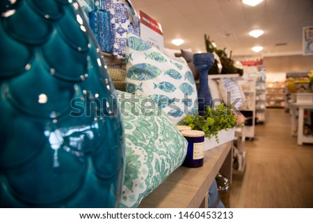 Perspective view of interior home décor store with pillows, candles and mantle pieces for sale.