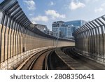 Perspective view of mass rail transit train passing through tracks with sound barrier in the city of Kuala Lumpur. Sound barrier tunnels are designed to minimize noise pollution.