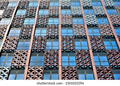 Perspective view of metal cladding over blue glass exterior with repeat geometric patterns and strong detail as abstract background