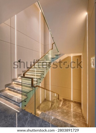 Perspective view of a modern grey marble staircase with embedded wall LED strip lights and glass balustrade.