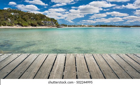Perspective View Of A Natural Wooden Jetty Platform Overlooking The Pristine Beach And The Noosa Heads Stunning Tropical Coastline During Summer, Little Cove, Sunshine Coast, Queensland, Australia