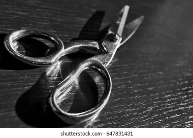 a perspective view in a pair of scissors on a table, shining for the sun light. (black and white version)