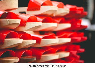 Perspective View Of Wooden Chinese Clogs In Red Color. 