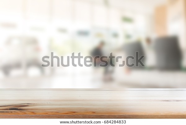 Perspective view of wooden Guest desk, reception desk or\
counter desk with empty copy space on hall of car showroom blurred\
background. 