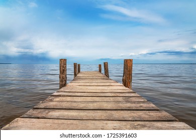 Perspective view of wooden pier at lake. Small bridge in water