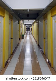 Perspective viewing of the yellow-white pattern walkway with a lot of private doors in the old residential apartment.