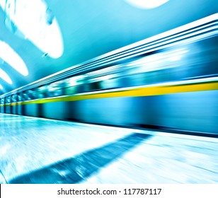 Perspective Wide Angle View Of Modern Light Blue Illuminated And Spacious Public Metro Marble Station With Fast Blurred Trail Of Train In Vanishing Traffic Motion