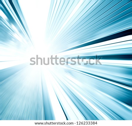Perspective wide angle view of modern light blue illuminated and spacious  high-speed moving escalator with fast blurred trail of handrail in vanishing traffic motion