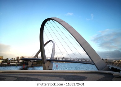 PERTH, AUSTRALIA - JUNE 18, 2018: People Walking Across Elizabeth Quay Bridge In Perth City. The 20m High Suspension Bridge Is Open To Pedestrians & Cyclists & Is An Iconic Architectural Feature.