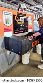 Perth, Australia - October 24th 2020: A Caucasian Female Standing At A Container Deposit Sorting Machine For Recycling Aluminium Cans And Glass Bottles.