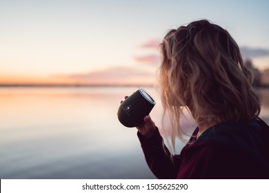 Perth, Australia - September 14th, 2019 : Early Morning Sunrise As Fit Girl Finishes Her Run By Drinking A Coffee From A Reusable Cup. The Sun Is Rising Over The Swan River With The City Behind. 