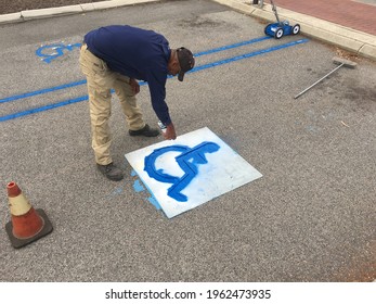 PERTH, WA - APR 23 2021:Road Worker Painting Handicap Signs.Around 15 Per Cent Of The World's Population, Or Estimated 1 Billion People, Live With Disabilities.