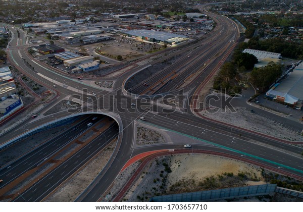 Perth, Western Australia /\
Australia - April 13, 2020: Aerial view from a highway crossroads\
in Perth with business park and urban area, Western Australia,\
Australia