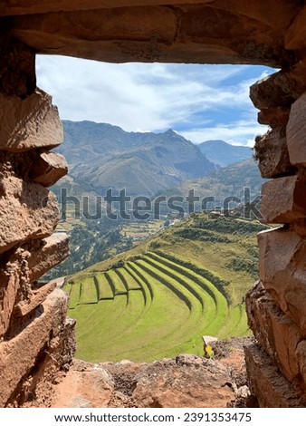 Peru Sacred valley of Inca Urubamba terraced fields view through ancient fortress window.