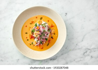 Peruvian cuisine dish - seabass ceviche with hot peppers, onions and yellow sauce, served in a white plate on a marble background. Restaurant seafood. - Shutterstock ID 1920287048