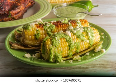 Peruvian elote street corn topped with queso fresco cheese and aji verde spicy green sauce
